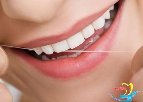 Dùng chỉ tơ là cách chăm sóc răng miệng sau khi cấy ghép implant nha khoa