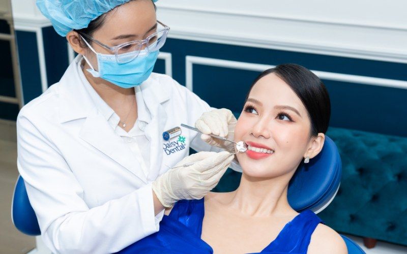 Bác sĩ điều trị tổng quát trình trạng răng miệng cho khách hàng