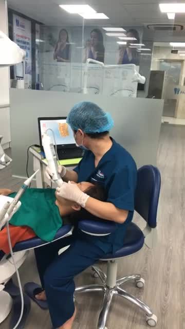 Cận cảnh bác sĩ của Nha khoa Paris Thái Thịnh đang thực hiện lấy dấu scan hàm răng cho khách hàng sử dụng liệu trình chỉnh nha khay trong Invisalign.
