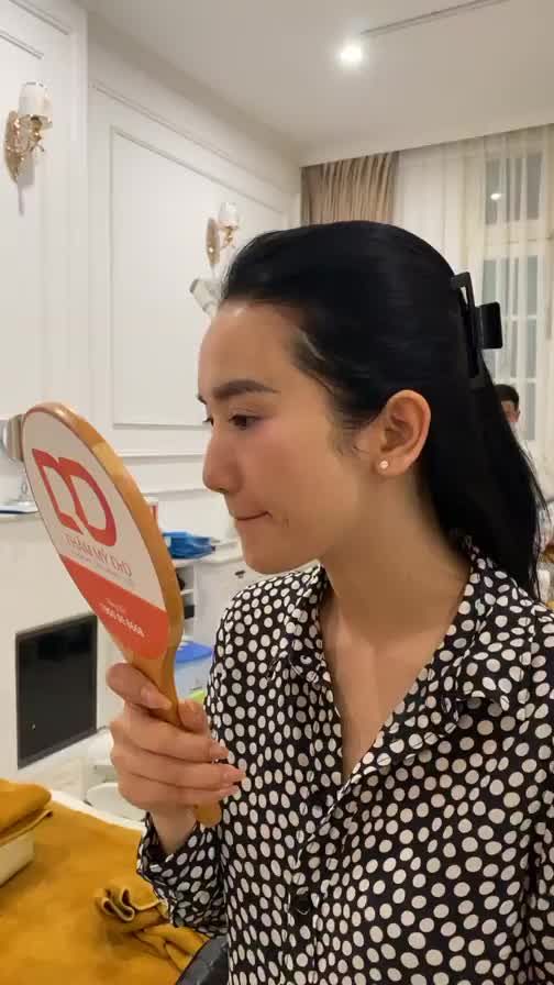 Khách hàng đã hoàn thành buổi điều trị Fotona 4D Active. Chị soi gương và thấy hài lòng về kết quả.